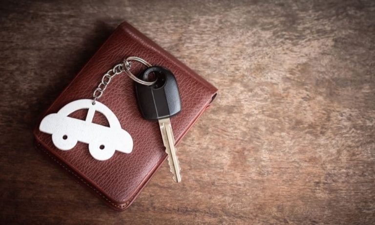 Car keys and a car keyring sit on a leather wallet