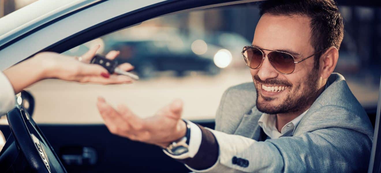 A smiling man collects his car keys