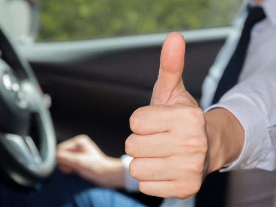 A driver behind the wheel puts his thumb up