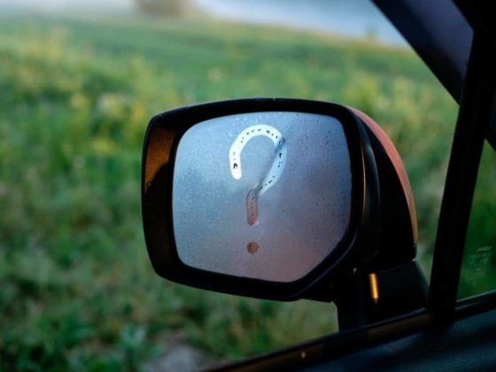 A car windscreen mirror with a question mark drawn in condensation